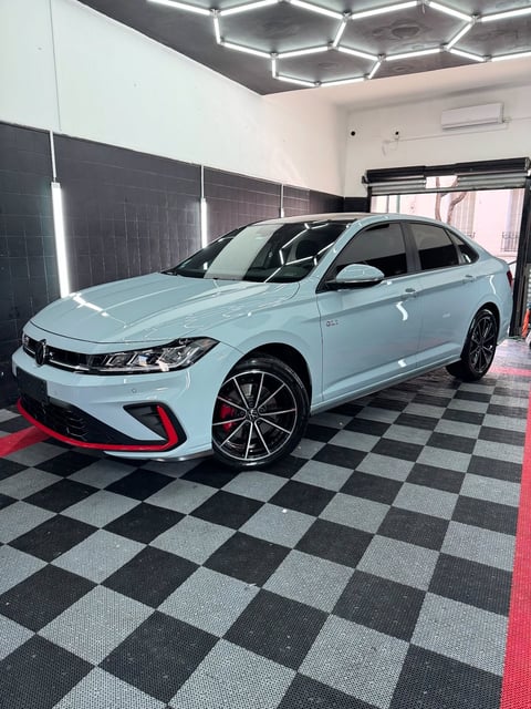 Volkswagen GLI azul claro en showroom moderno con piso a cuadros